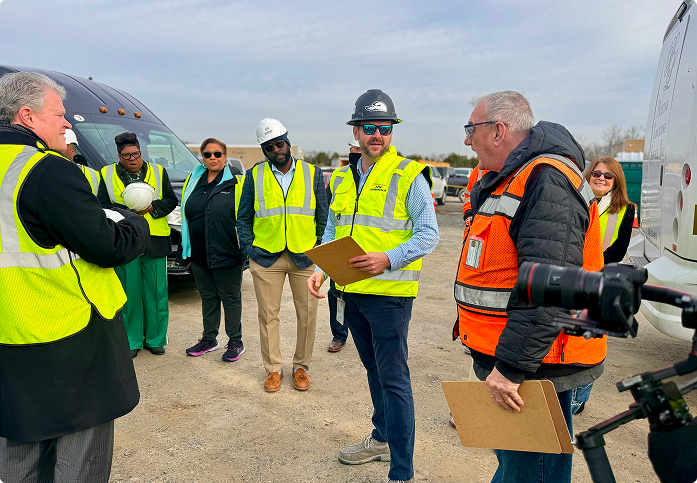 Group of professionals in safety vests at a construction site in Central Alabama.