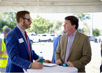 Two men in business attire talking at an outdoor event in Central Alabama.