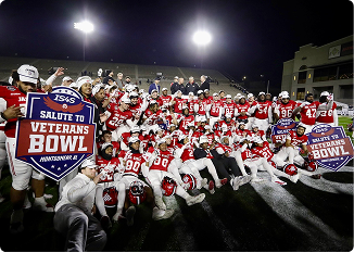 Football team celebrating victory at Central Alabama Veterans Bowl.