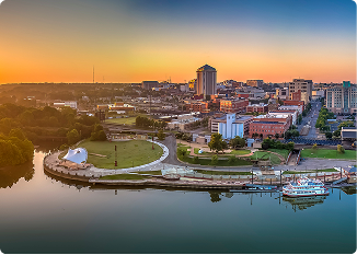 Scenic view of downtown Montgomery Alabama during sunset with river and city skyline.
