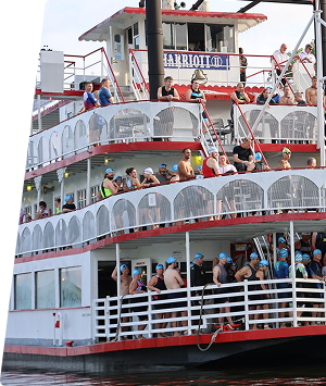People enjoying a riverboat cruise on the Alabama River with multiple decks and scenic views.