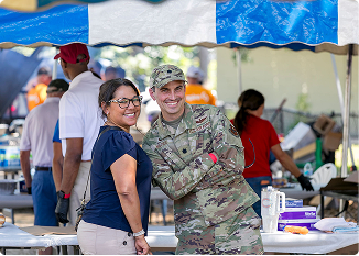 Soldier and woman smiling at community event in Central Alabama.