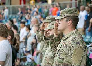 Soldiers in uniform saluting at a community event in Central Alabama.